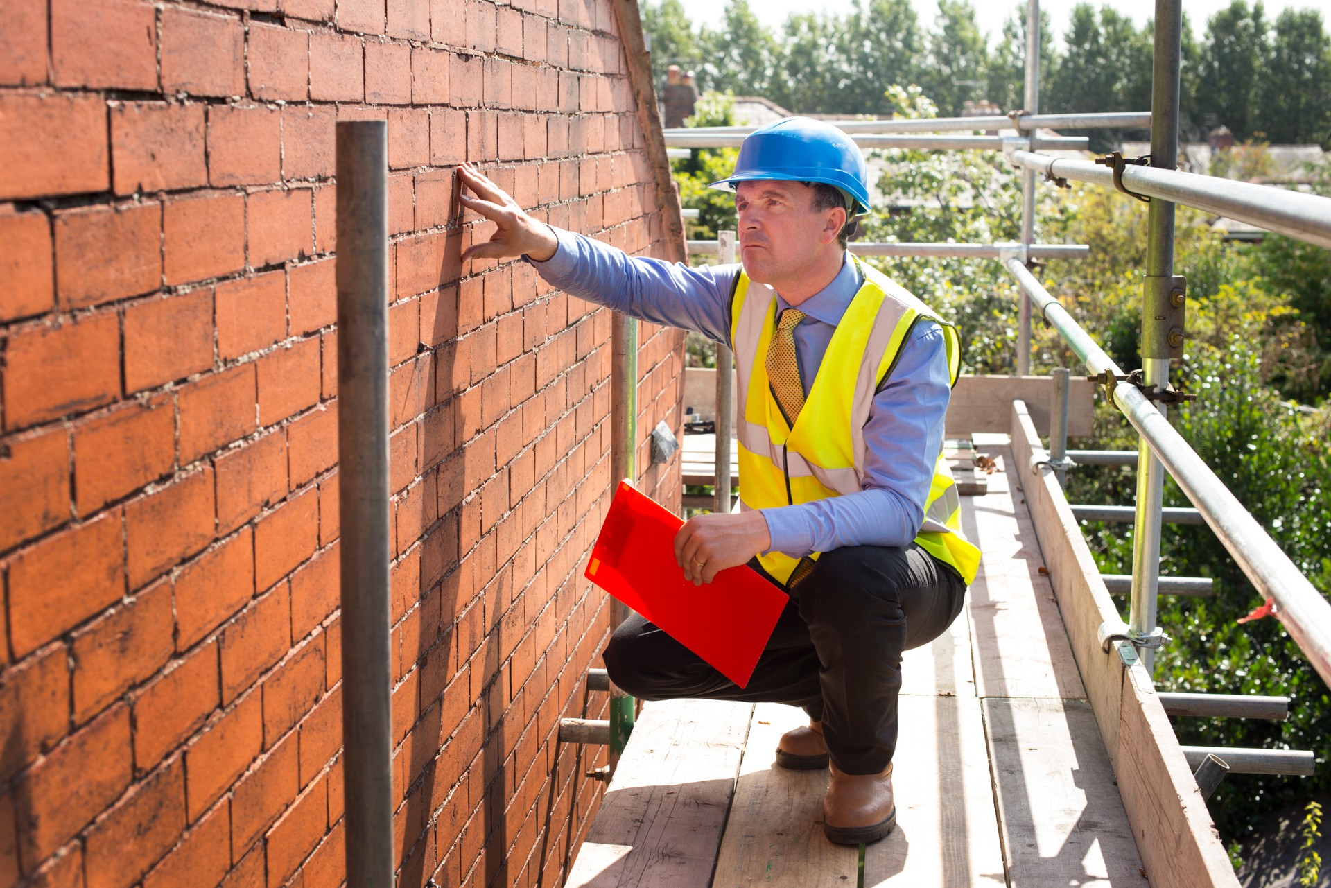 builder assesses brickwork on a gable end